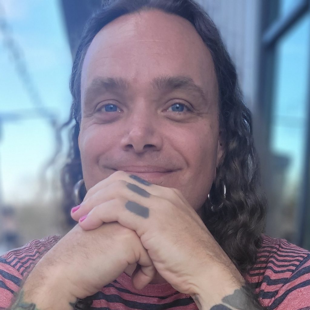 Silver Bowen is a middle aged white male with long curly hair and blue eyes.
