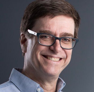 Richard Gauder is a Caucasian male with short, dark hair wearing dark rimmed glasses and a blue button-down shirt.
