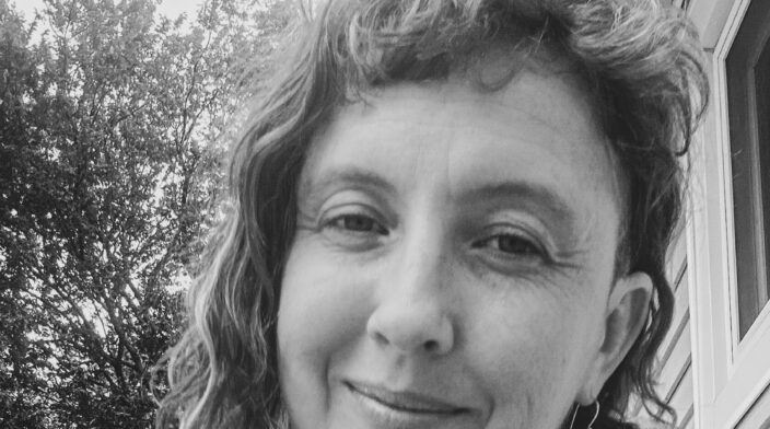 Black and white close up of Julie Johnson with half smile