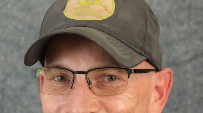 Eric Amundson is a smiley white dude wearing a blue cap and glasses