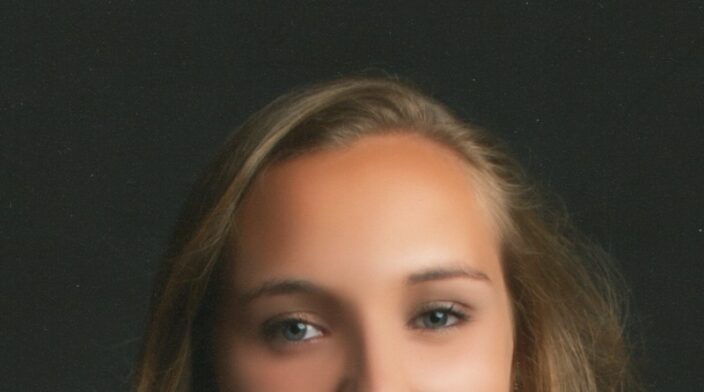 Samantha Merrett is a white woman in her 20's with long blonde hair and she is smiling directly at the camera.