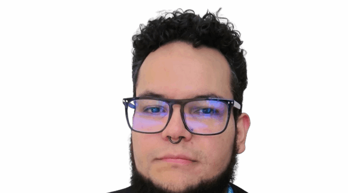 Photo of a Venezuelan man (he/him) with morena skin, curly dark hair, a short beard, and a septum piercing. He’s wearing black plastic-frame glasses, a black “WordCamp Bogotá 2024” t-shirt and a turquoise WordPress lanyard, looking straight at the camera with a calm expression.