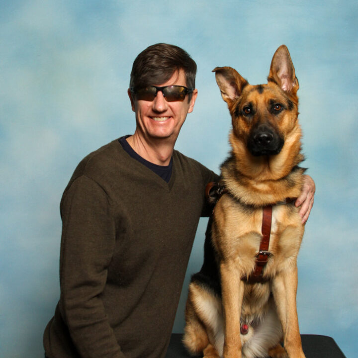 Ed Summers is a middle-aged white male standing beside his Seeing Eye Dog, Loki.